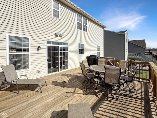 wooden deck featuring outdoor dining area and a grill