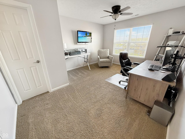 office area with visible vents, a textured ceiling, carpet floors, baseboards, and ceiling fan