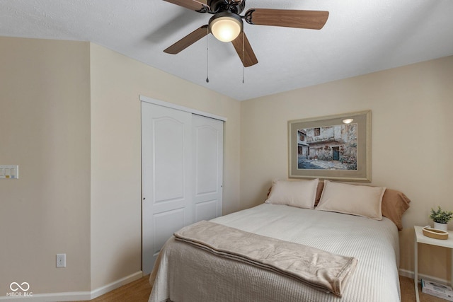 bedroom featuring a ceiling fan, a closet, and baseboards