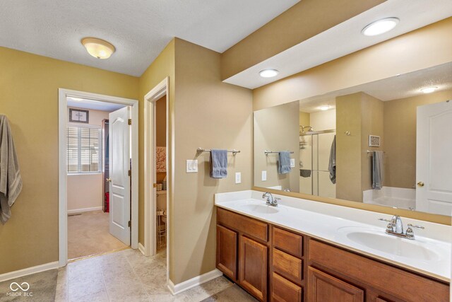 bathroom with a sink, baseboards, double vanity, and a shower stall