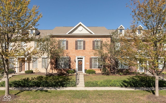 view of front of home with brick siding and a front yard