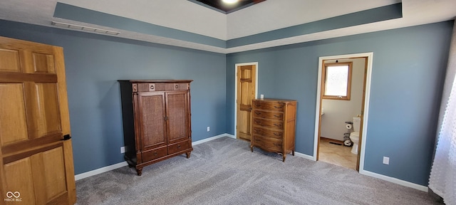 bedroom with connected bathroom, baseboards, visible vents, and light carpet