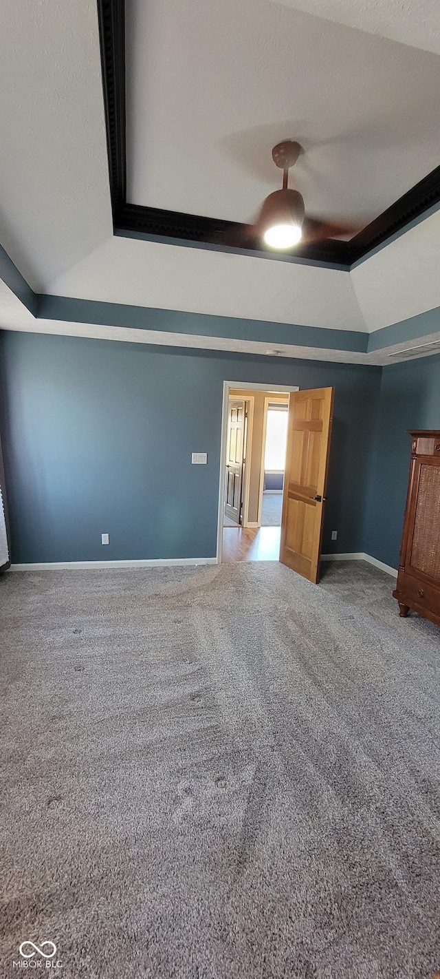 unfurnished bedroom with carpet flooring, a textured ceiling, baseboards, and vaulted ceiling