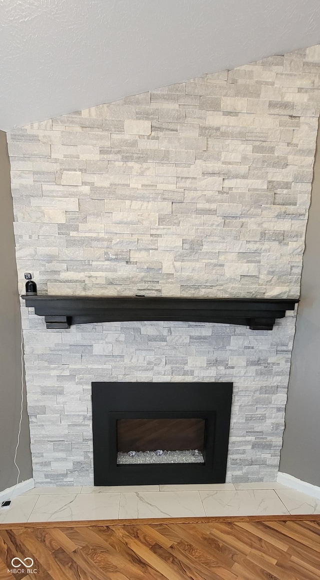 room details featuring a textured ceiling, wood finished floors, and a fireplace