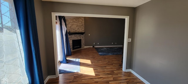 corridor with baseboards and wood finished floors