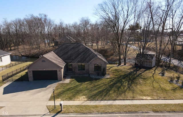 view of front facade with brick siding, a front lawn, fence, driveway, and an attached garage