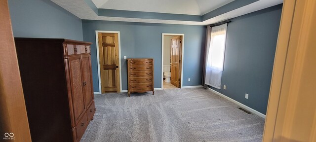 unfurnished bedroom with visible vents, baseboards, ensuite bath, and carpet flooring