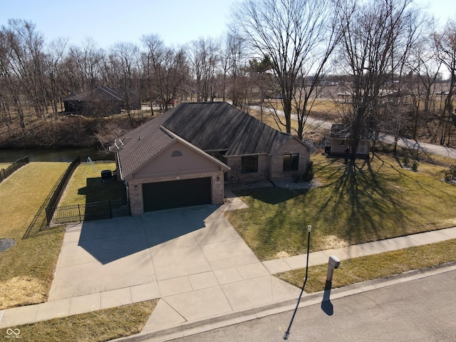 view of front of house with a front yard, fence, driveway, a garage, and brick siding