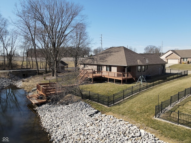 exterior space with a deck with water view and fence