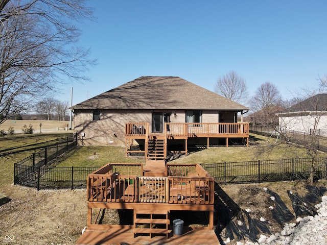 back of property with stairway, a yard, a fenced backyard, a shingled roof, and a deck