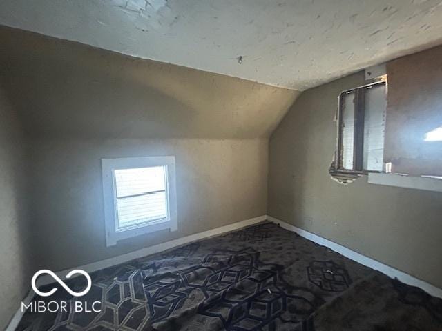 bonus room featuring baseboards, lofted ceiling, and carpet floors