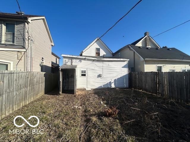 view of side of property with an outdoor structure and a fenced backyard