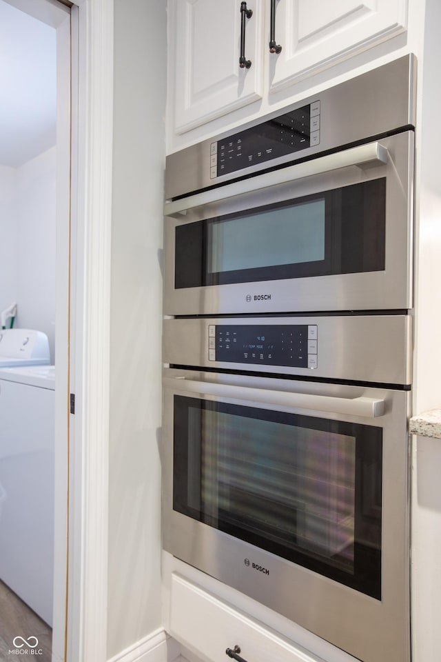 interior details featuring washer / dryer, double oven, white cabinets, and light countertops