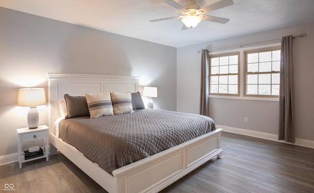 bedroom with a ceiling fan, wood finished floors, and baseboards