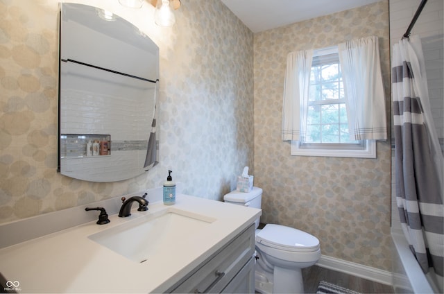 full bathroom with baseboards, toilet, vanity, and wallpapered walls