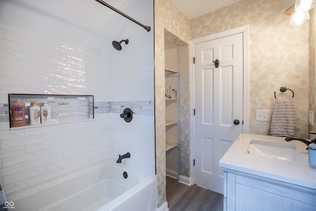 bathroom with shower / tub combination, wood finished floors, vanity, and wallpapered walls