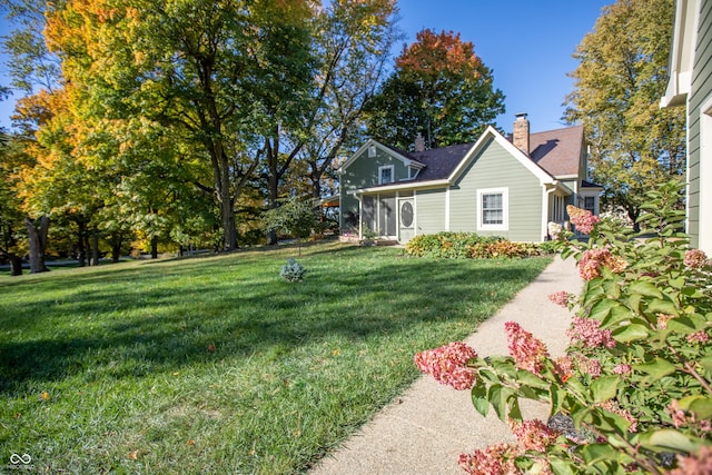 view of home's exterior featuring a lawn and a chimney