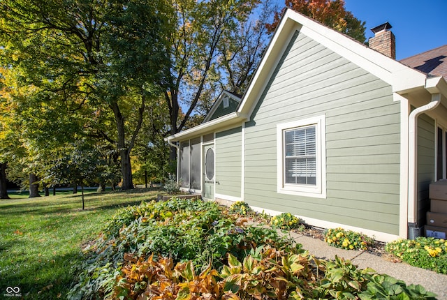 view of property exterior with a yard and a chimney