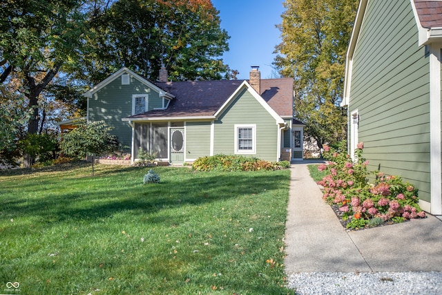 view of front of home with a front yard and a chimney