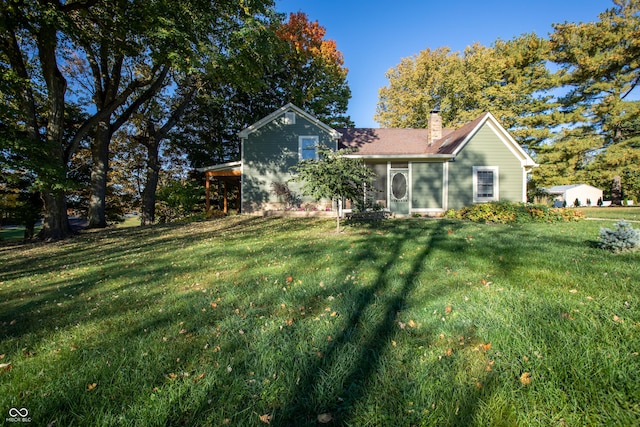 rear view of house with a yard and a chimney