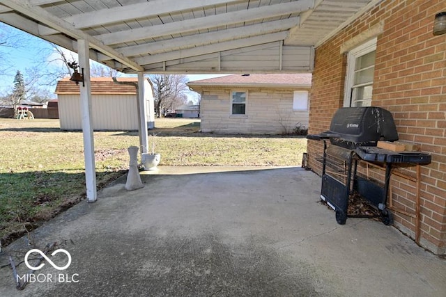 view of patio featuring an outbuilding, a shed, and grilling area