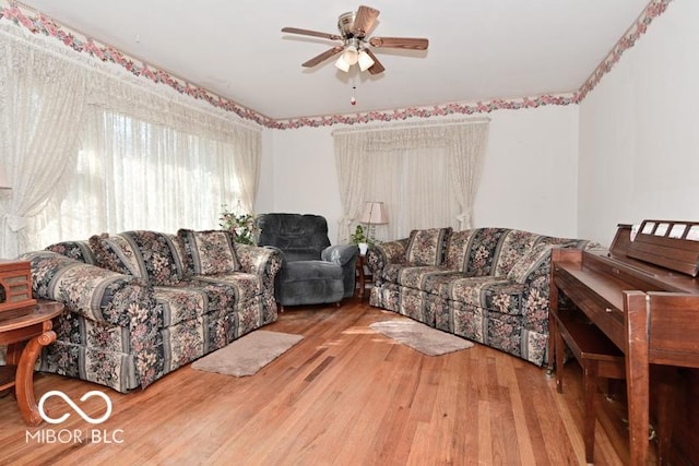 living room with wood finished floors and ceiling fan