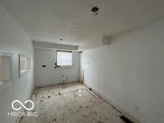 unfurnished room featuring visible vents and a textured ceiling