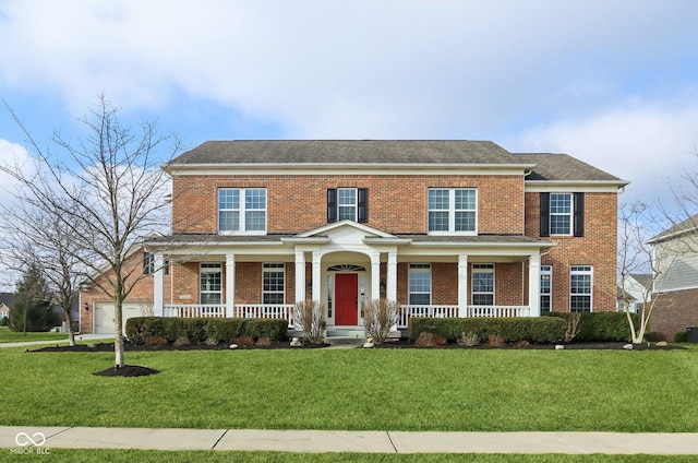 view of front of home with a garage, brick siding, covered porch, and a front yard