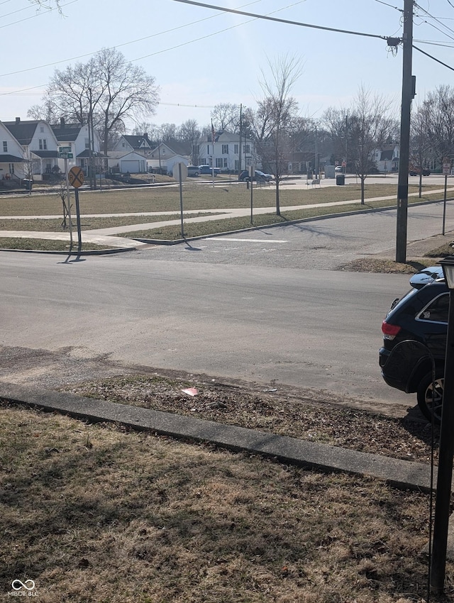 view of street featuring a residential view, traffic signs, and sidewalks