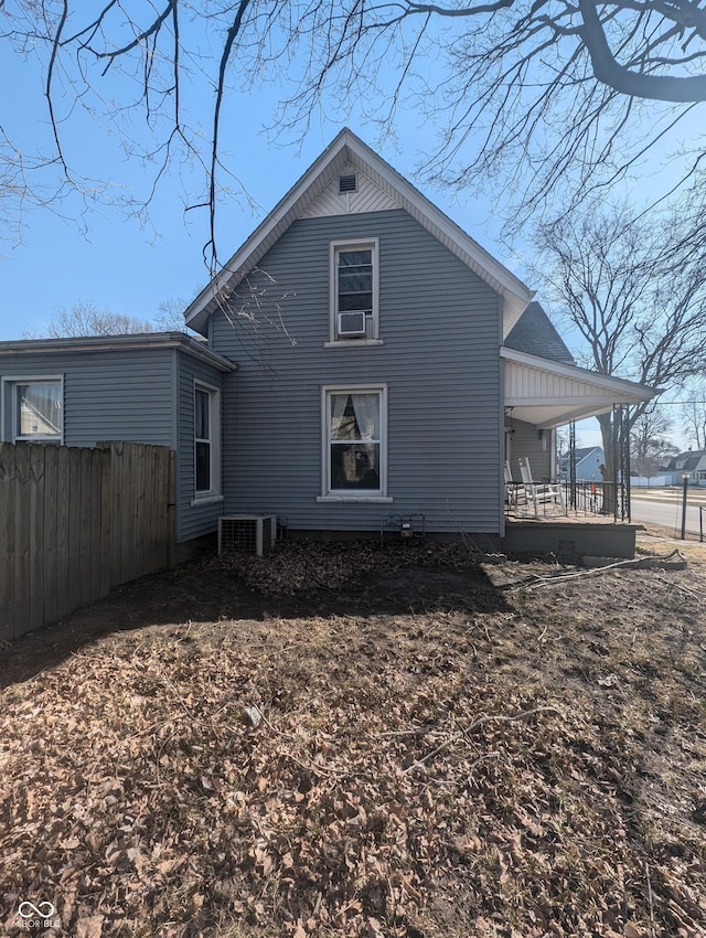 back of house featuring covered porch, central AC unit, and fence