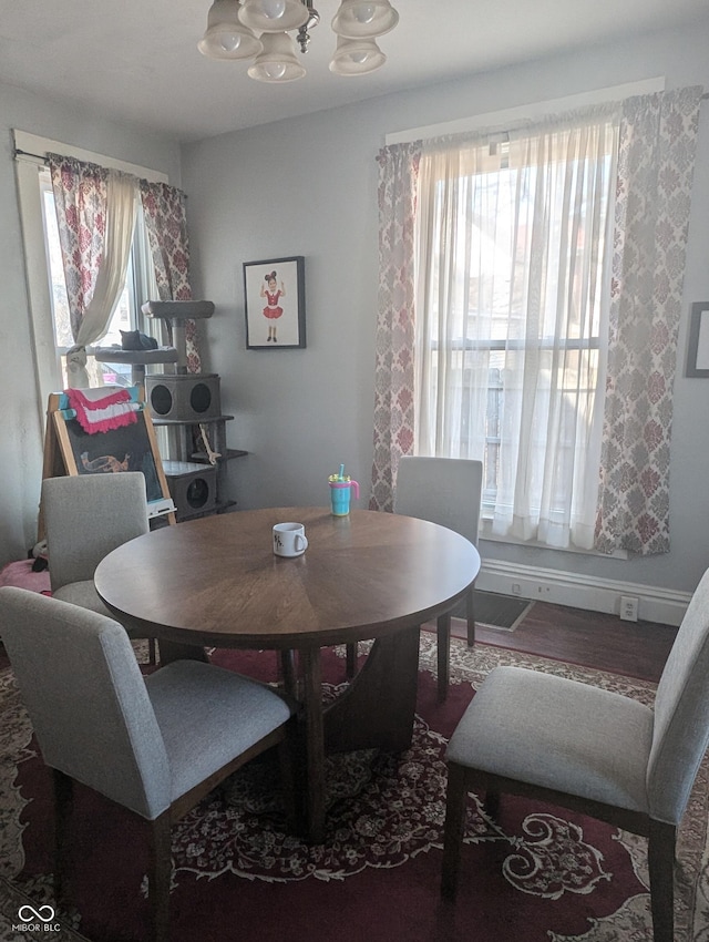 dining space with baseboards and an inviting chandelier