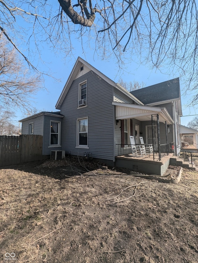 view of home's exterior with a porch and fence