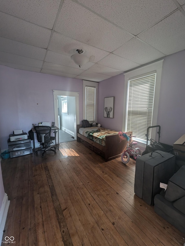 living room featuring hardwood / wood-style flooring and a drop ceiling