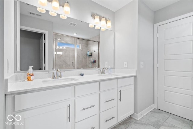 bathroom with a shower stall, double vanity, visible vents, and a sink