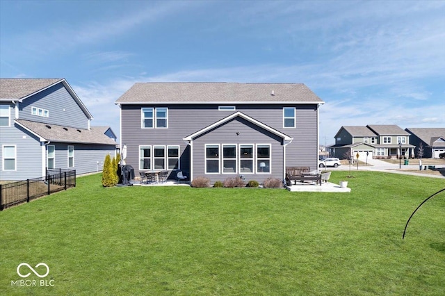 rear view of house with a yard, fence, and a patio area