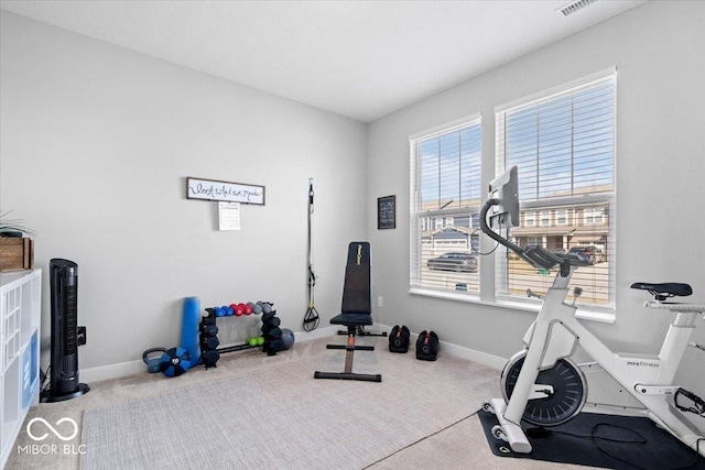 exercise area with visible vents, baseboards, and carpet flooring