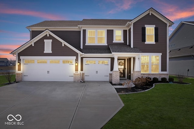 view of front facade featuring a shingled roof, concrete driveway, a garage, a lawn, and brick siding