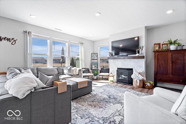 living room with recessed lighting, a fireplace, and wood finished floors