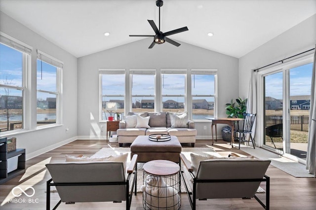 living room featuring baseboards, wood finished floors, and vaulted ceiling