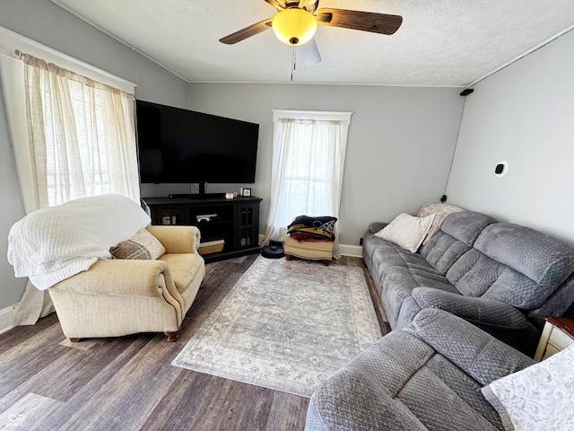 living area featuring ceiling fan, wood finished floors, baseboards, and a textured ceiling