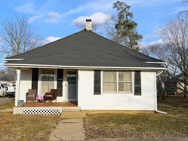 view of front of home featuring a chimney and roof with shingles