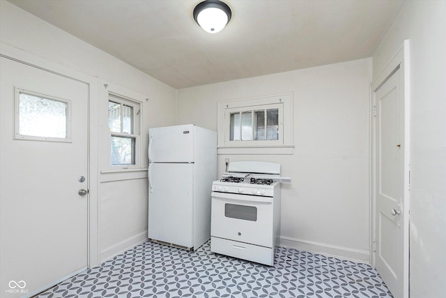 kitchen featuring white appliances, light floors, and baseboards