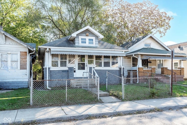 bungalow-style home featuring a fenced front yard, a front yard, and a gate