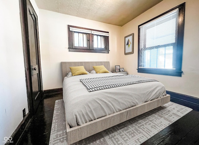 bedroom with baseboards and a textured ceiling