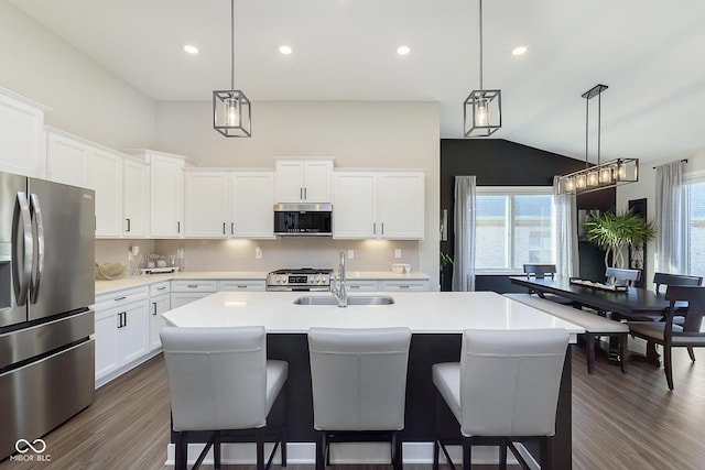 kitchen featuring a sink, stainless steel appliances, dark wood-style floors, and light countertops