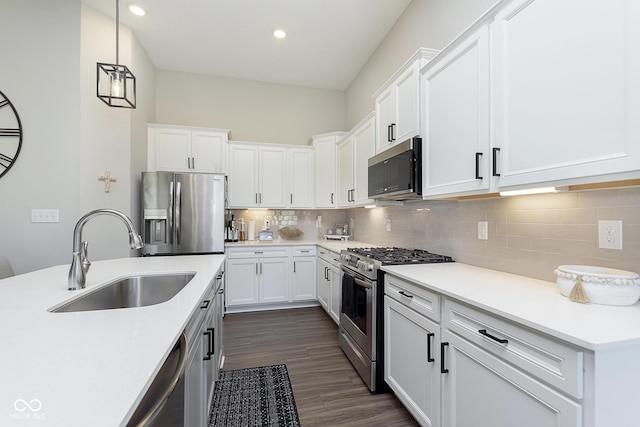 kitchen with tasteful backsplash, stainless steel appliances, light countertops, and a sink