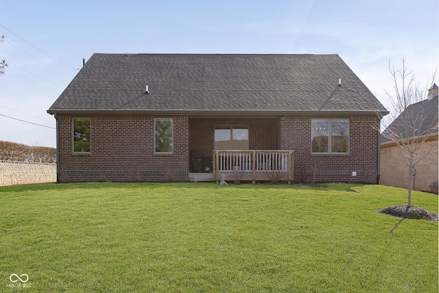 rear view of property featuring brick siding, a shingled roof, and a yard