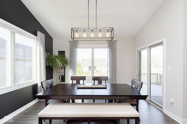 dining room with baseboards, dark wood finished floors, and vaulted ceiling