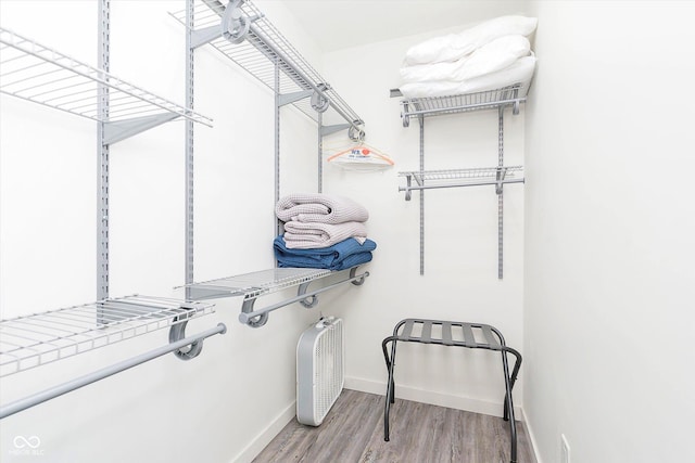 walk in closet with wood finished floors