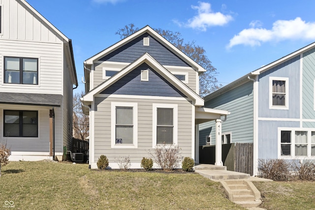 view of front of property featuring central air condition unit, board and batten siding, and a front lawn